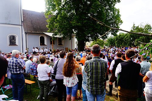 Viele Personen nehmen an einem OpenAir-Gottesdienst unter freiem Himmel zum Kirchenpatrozinium Maria Himmelfahrt teil.
